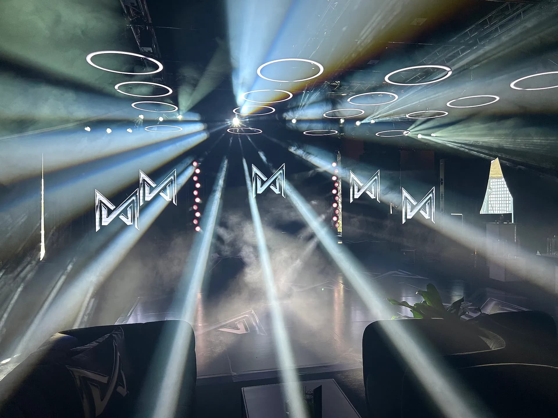 Green laser show over LED video walls and lighting truss at an event produced by Nicholson Events