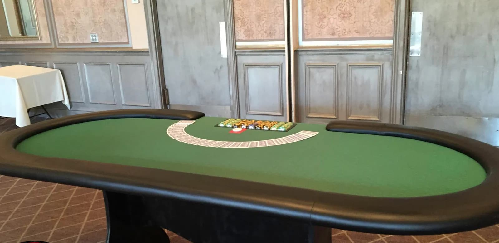 Full-size Texas Hold'em poker table rental with green felt and chips at an elegant Connecticut casino party