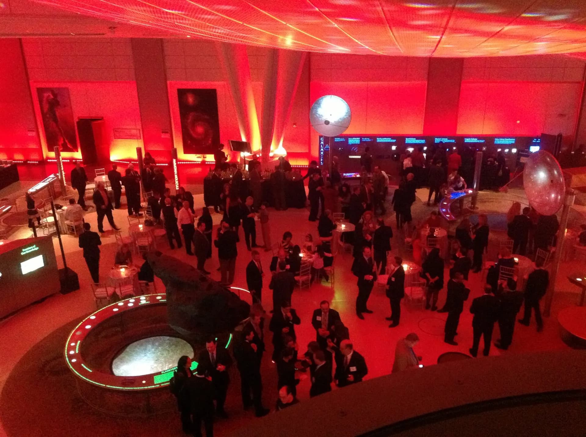 Aerial view of a Nicholson Events gala lit in deep red, packed tables and dance floor below