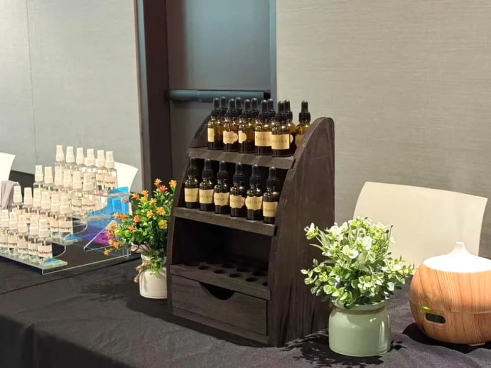 Guest hand-mixing a custom essential oil blend from aromatic notes at an event wellness station