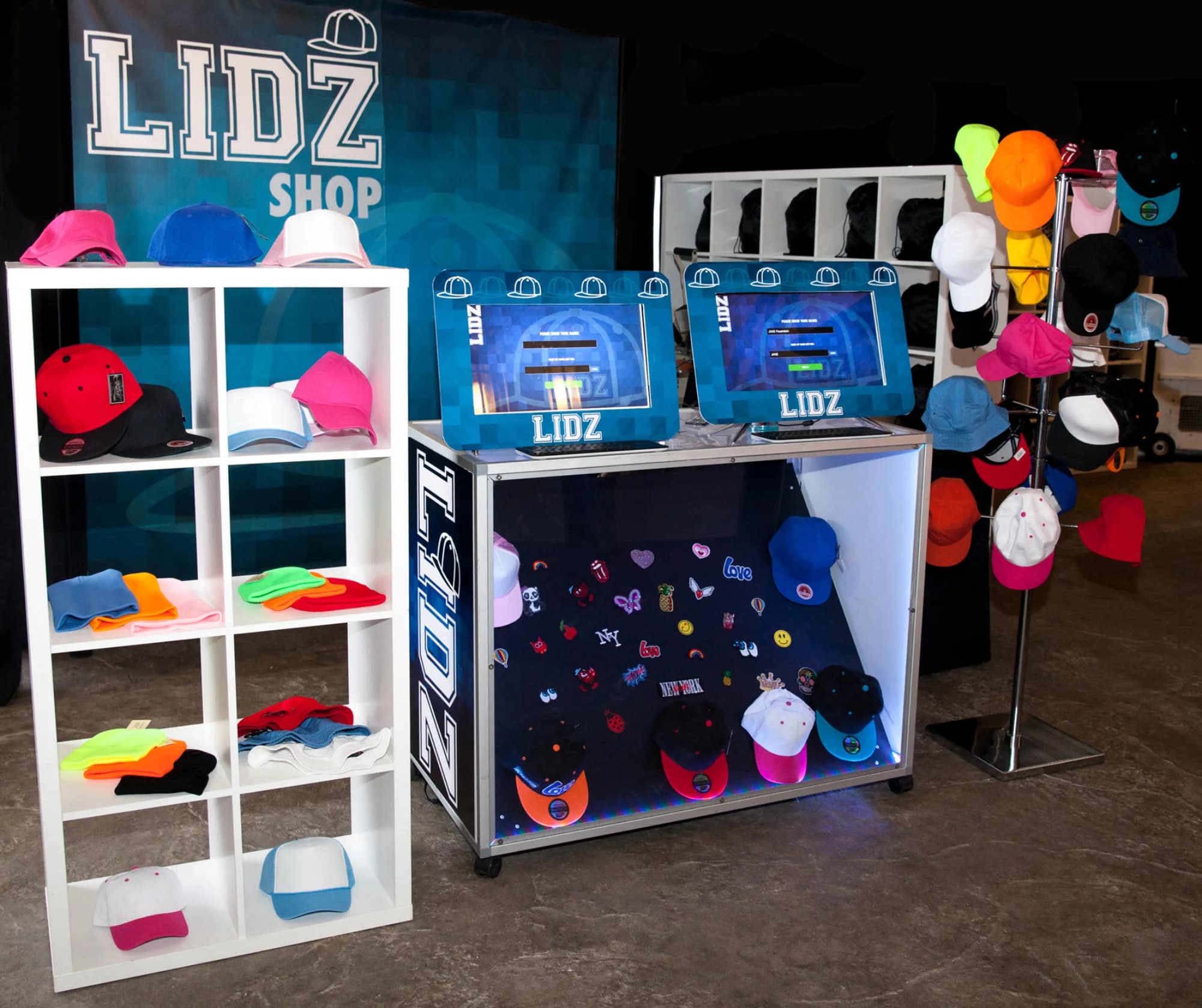 LIDZ custom hat station with embroidered hats in assorted colors and styles on display at an event