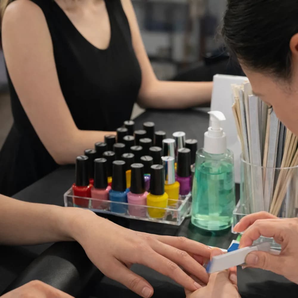 Nail artist creating custom glam nail designs on the spot at an event nail art station