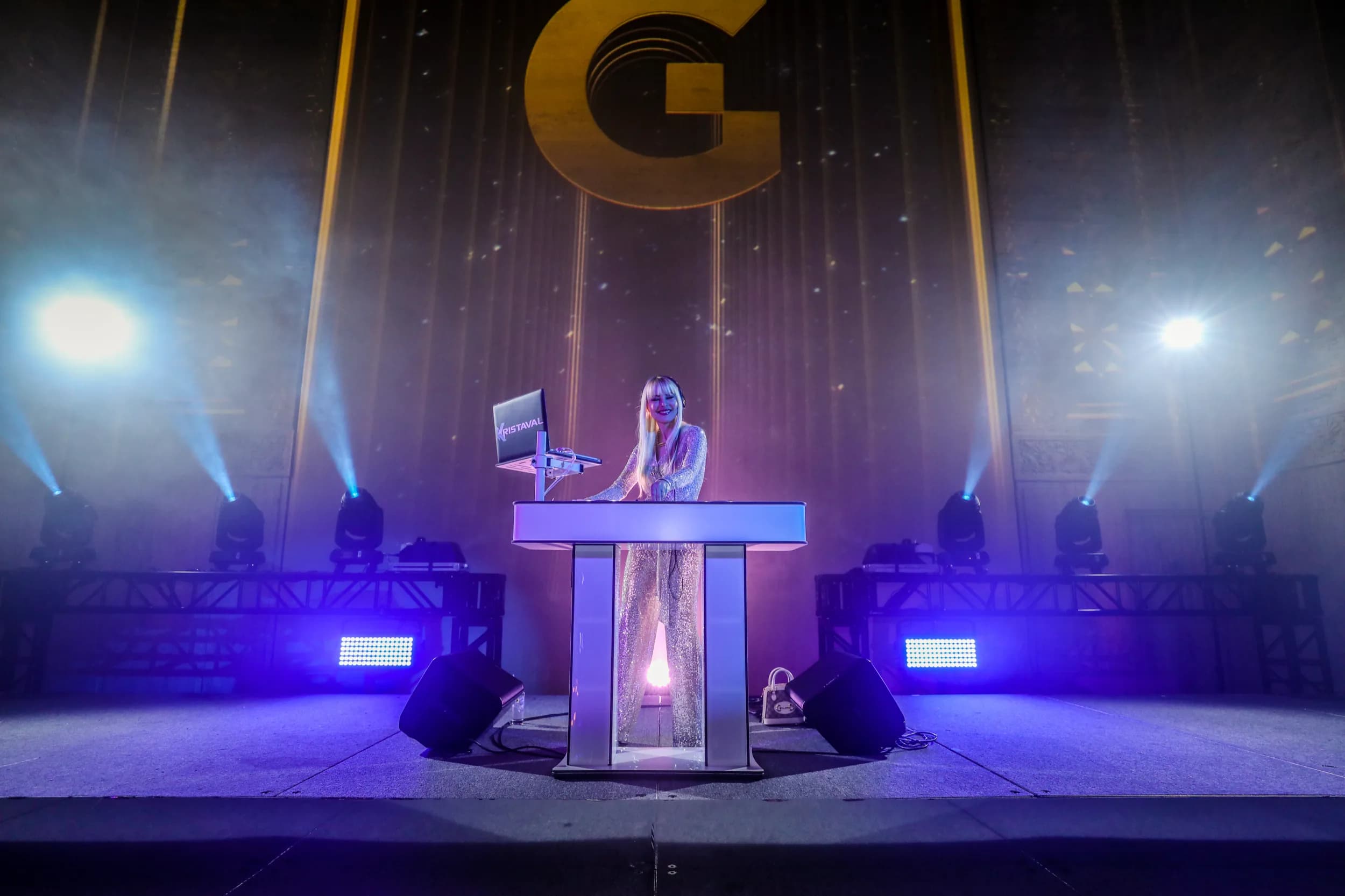 DJ Kristaval performing a solo gala set under production lighting, shown as an atmospheric backdrop