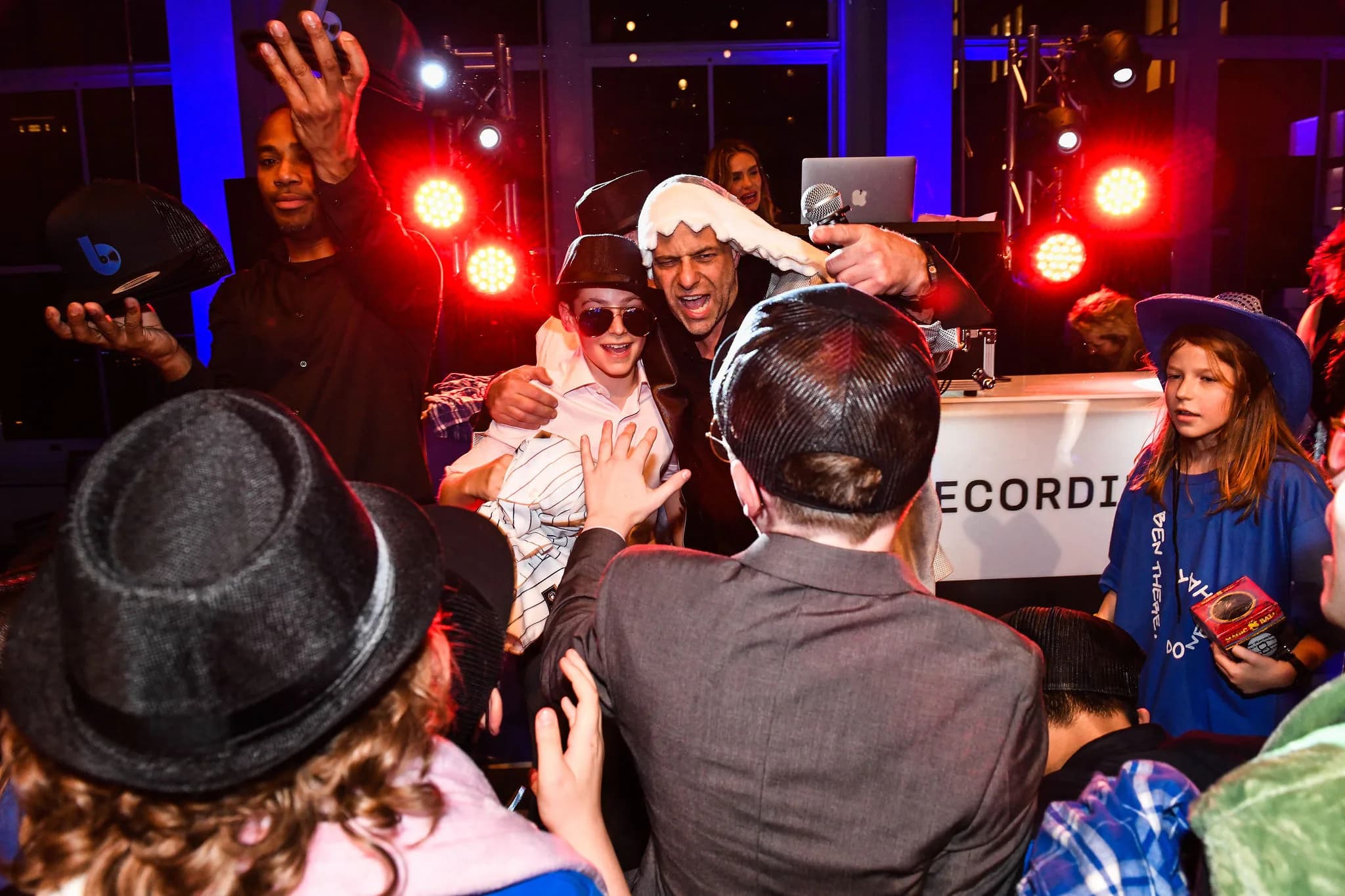 MC Shiran Nicholson on the platform with a packed dance floor at a Bat Mitzvah event in a New York venue