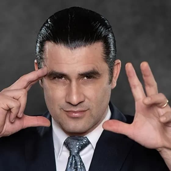 Mentalist Ken Salaz framing his face with his hands in a dramatic studio portrait, the Master of Astonishment