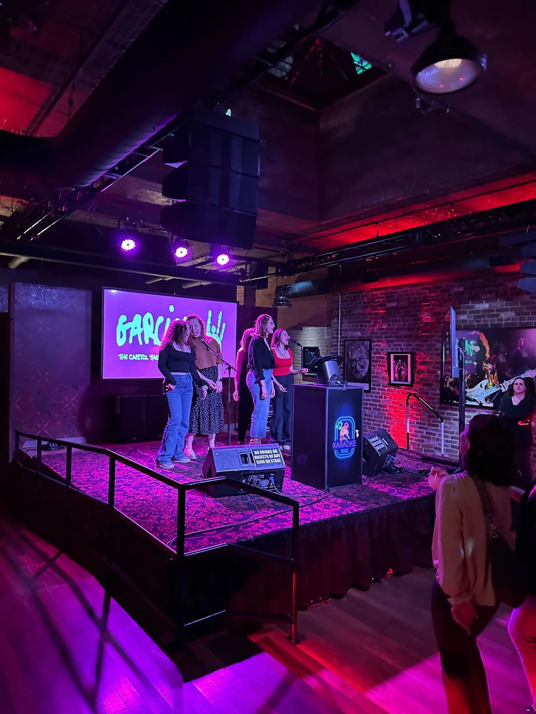 Karaoke stage setup with neon sign and purple lighting for corporate and mitzvah events