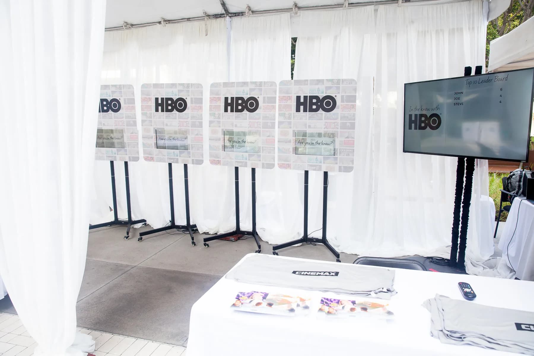 Touch screen trivia game at a corporate event in New York, guests tapping answers on individual touchscreen tablets with live leaderboard display