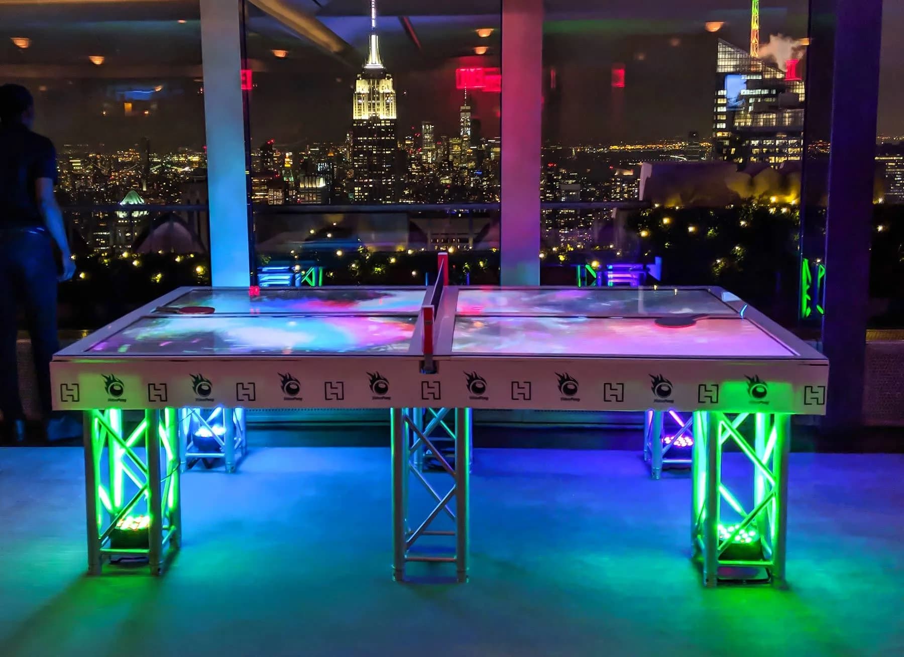 Video ping pong table with HD TV playing surface showing party video underneath live play at a bar mitzvah or corporate gala in NYC