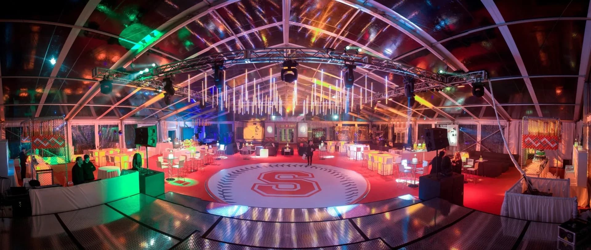 Panoramic view of a bar mitzvah tent production with LED lighting, stage setup, and dance floor in New York