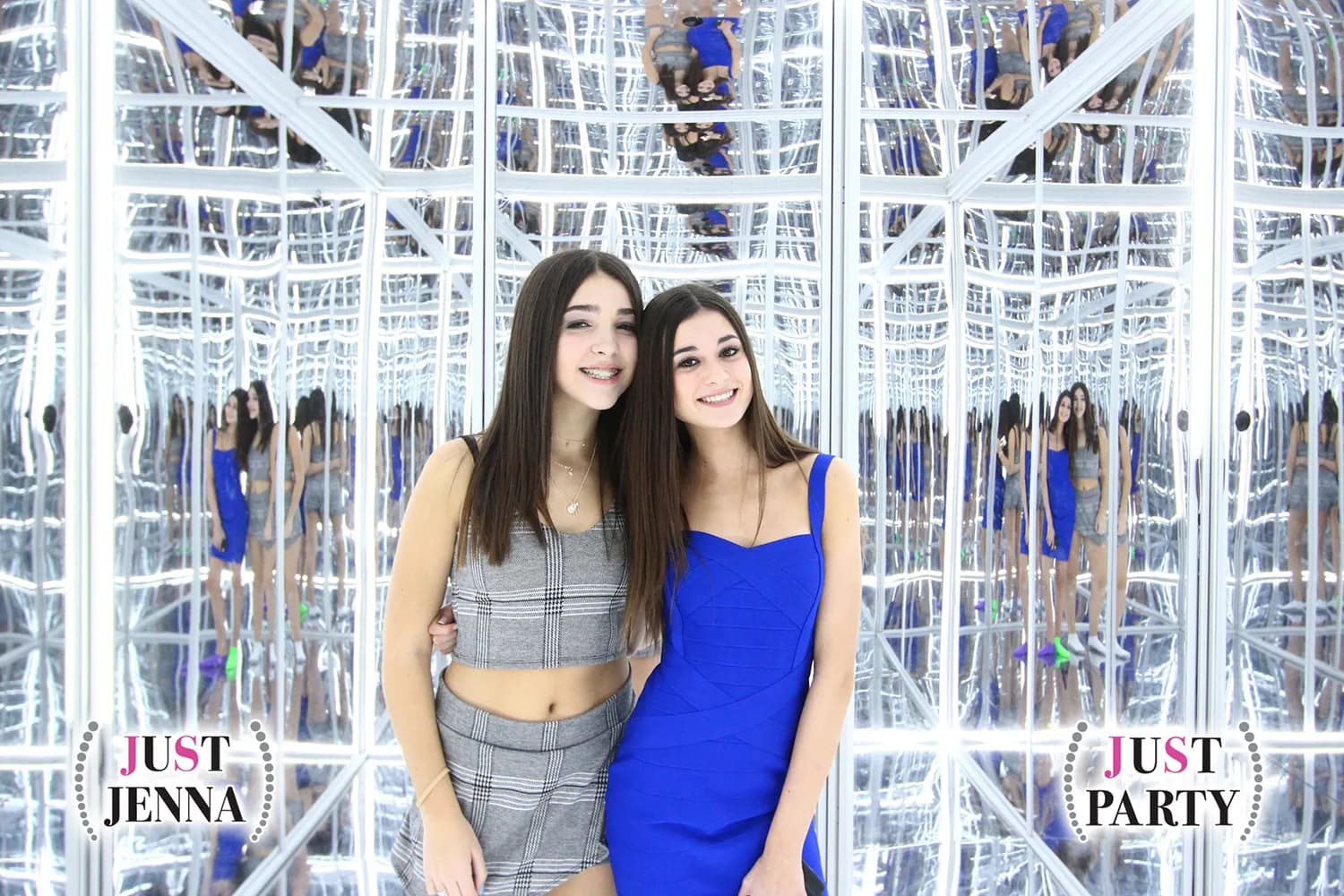 Guests posing inside an infinite mirror photo booth with glowing LED reflections at a celebration