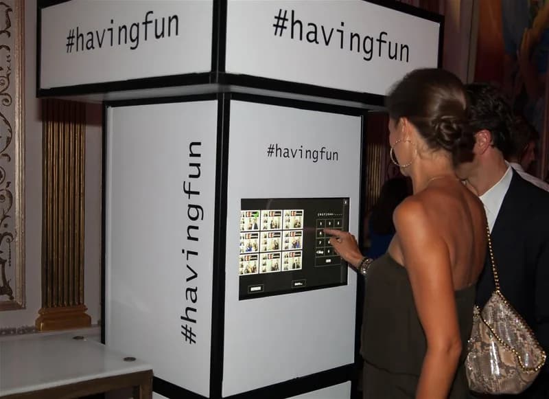 Guest using a social media hashtag kiosk to share event photos instantly at a celebration
