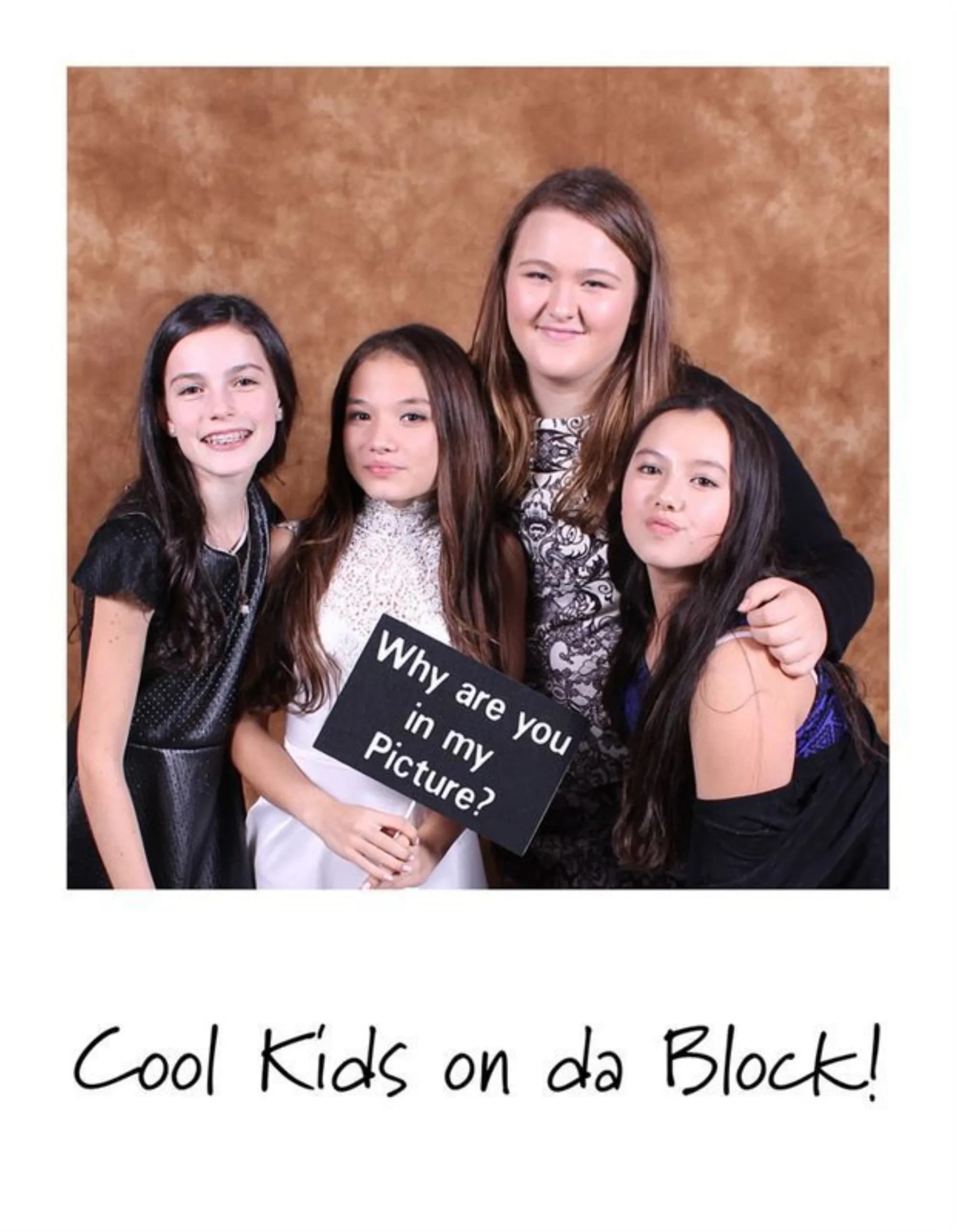 Group of guests posing with a framed Polaroid-format print keepsake at a celebration