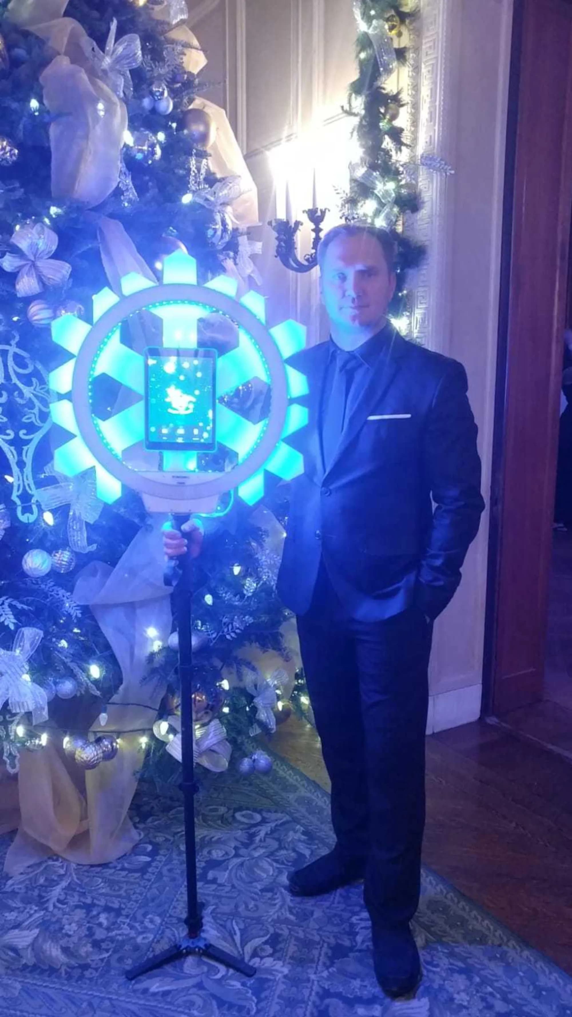 Roaming snowflake GIF attendant with themed ring light beside a holiday tree
