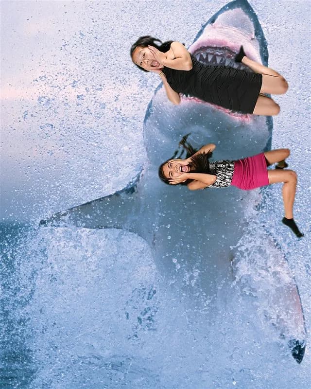 Two guests composited into a jump shot with a great white shark rising from the ocean behind them