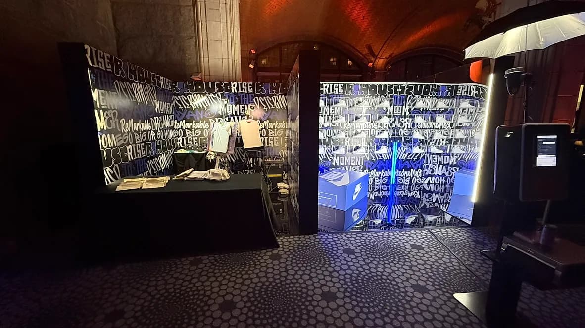 Custom airbrush T-shirt station with a branded sneaker-box build-out at a corporate activation by Nicholson Events