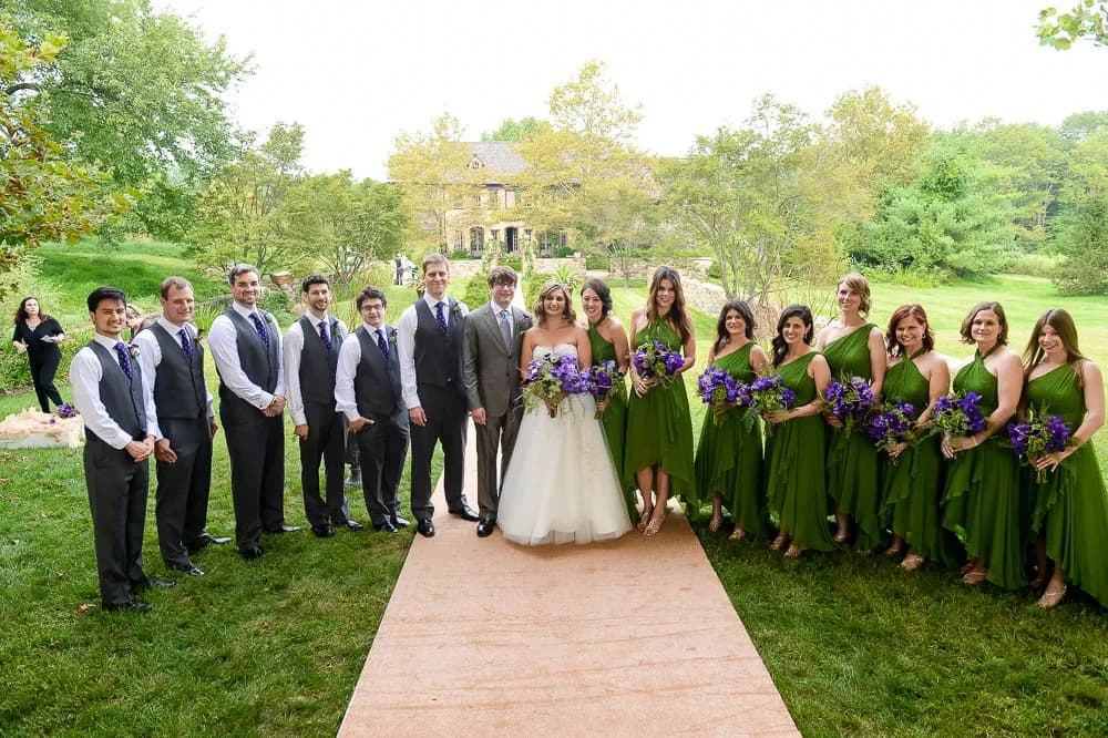 Wedding party gathered on the lawn of a stone country estate