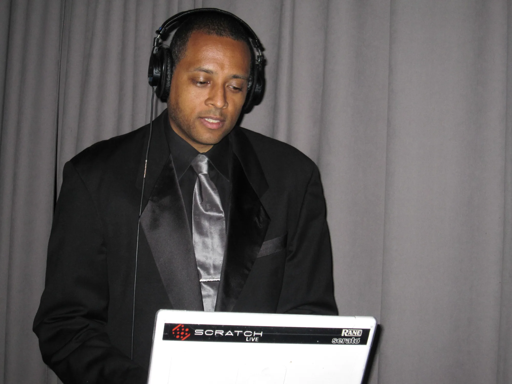 DJ mixing a live silent party channel on headphones for a multi-channel set by Nicholson Events